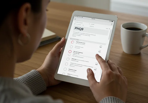 Person taking a PHQ9 emotional checkup on a tablet.